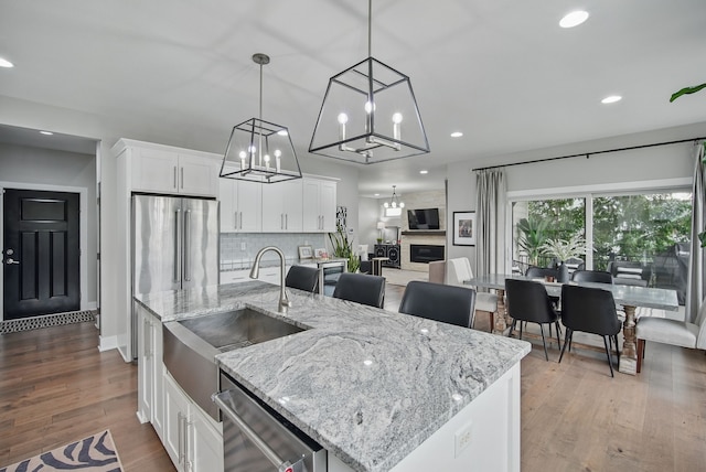 16202 Brookview Dr, Urbandale, IA 50323 - kitchen with stainless steel appliances, a sink, a chandelier, white cabinets, and recessed lighting
