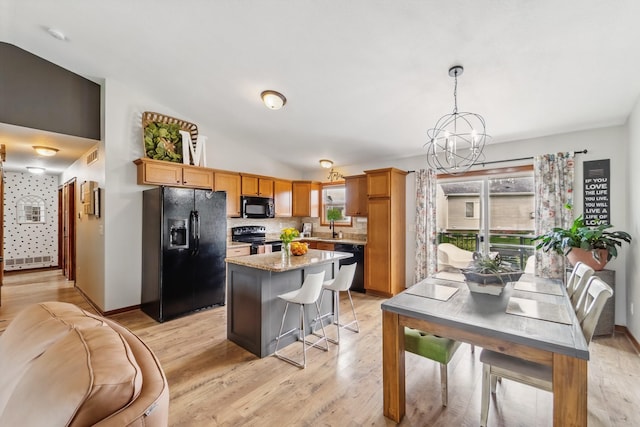 2009 NW Boulder Ridge Ln, Ankeny, IA 50023 - kitchen with black appliances, a sink, a chandelier, tasteful backsplash, and lofted ceiling