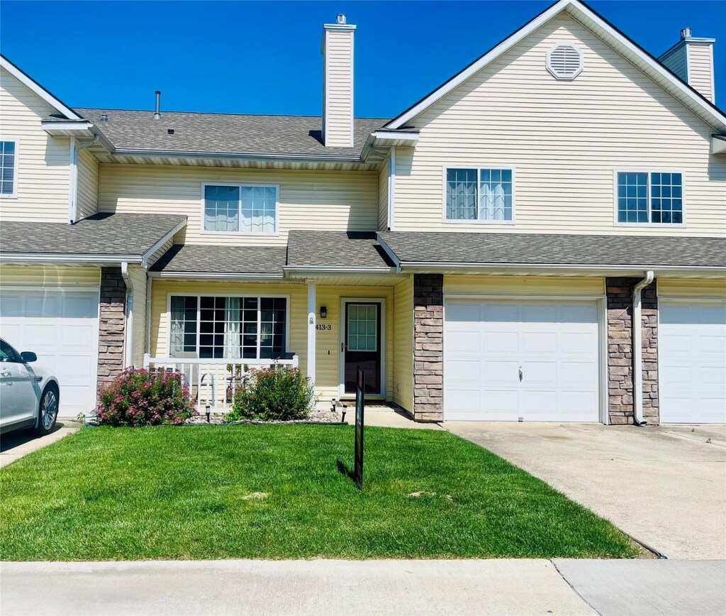 1413 SE Delaware Ave Unit 3, Ankeny, IA 50021 - view of property featuring a chimney, a front yard, a porch, and stone siding