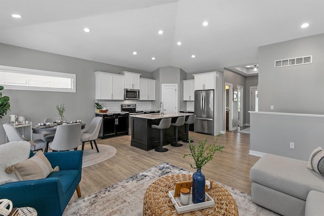 1350 97th St, West Des Moines, IA 50266 - living room featuring lofted ceiling, light wood finished floors, recessed lighting, and baseboards