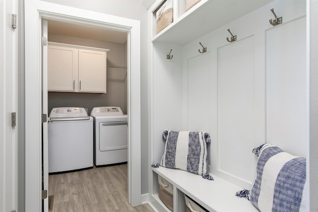1350 97th St, West Des Moines, IA 50266 - laundry area featuring separate washer and dryer, light wood-style floors, and cabinet space