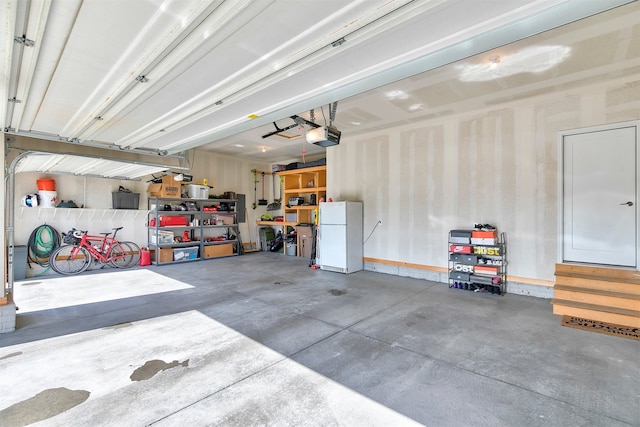 1350 97th St, West Des Moines, IA 50266 - garage featuring freestanding refrigerator and a garage door opener