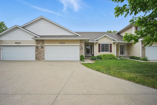6082 Sheffield Cir, Johnston, IA 50131 - multi unit property featuring a front lawn, a garage, driveway, stone siding, and a shingled roof