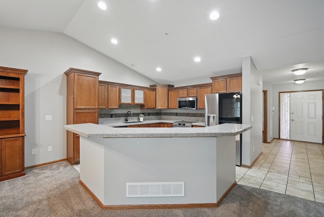 6082 Sheffield Cir, Johnston, IA 50131 - kitchen with a sink, appliances with stainless steel finishes, a kitchen island, lofted ceiling, and brown cabinets