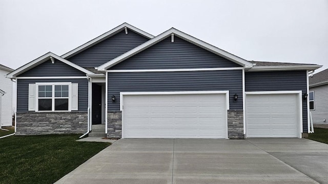 4304 NE 12th St, Ankeny, IA 50021 - view of front of property featuring stone siding, a garage, concrete driveway, and a front yard