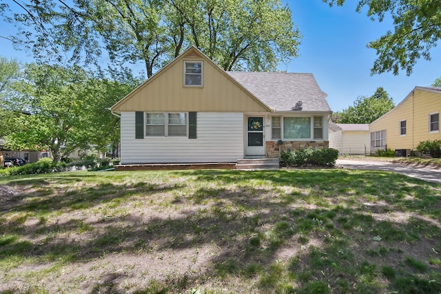 4147 E 7th St, Des Moines, IA 50313 - view of front of house with board and batten siding, a front yard, and roof with shingles