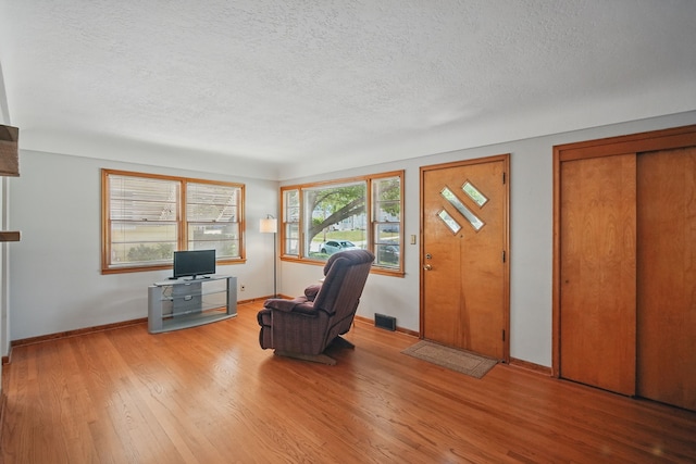4147 E 7th St, Des Moines, IA 50313 - sitting room with a textured ceiling, light wood-style flooring, and baseboards