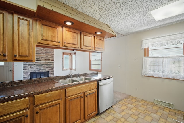 4147 E 7th St, Des Moines, IA 50313 - kitchen featuring dishwasher, a sink, brown cabinets, and healthy amount of natural light