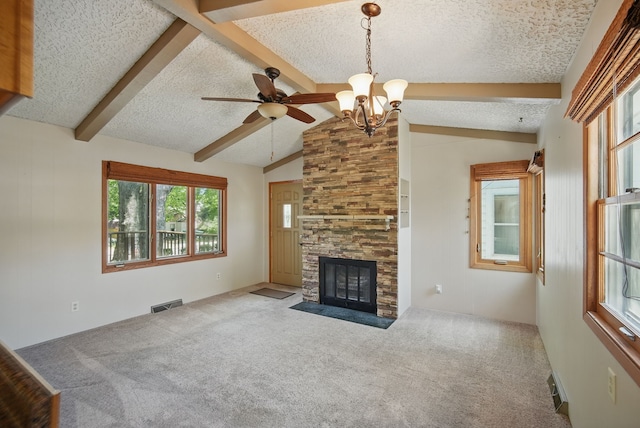 4147 E 7th St, Des Moines, IA 50313 - unfurnished living room featuring a textured ceiling, healthy amount of natural light, a fireplace, and carpet