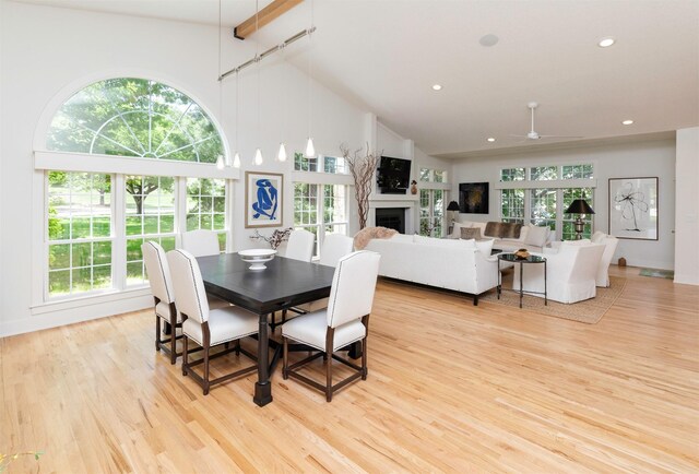 8115 Cobblestone Ct, Urbandale, IA 50322 - dining space featuring high vaulted ceiling, light wood-style flooring, a ceiling fan, a fireplace, and recessed lighting