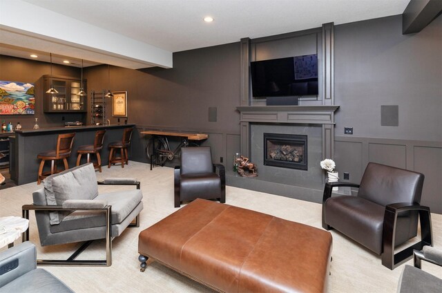 8115 Cobblestone Ct, Urbandale, IA 50322 - living room with a decorative wall, a community bar, a fireplace, recessed lighting, and a wainscoted wall