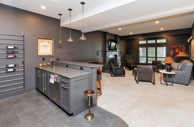 8115 Cobblestone Ct, Urbandale, IA 50322 - kitchen with a peninsula, gray cabinetry, a kitchen breakfast bar, open floor plan, and a sink