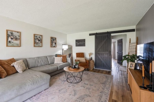 306 E Buchanan St, Baxter, IA 50028 - living room with a barn door, wood finished floors, and a textured ceiling