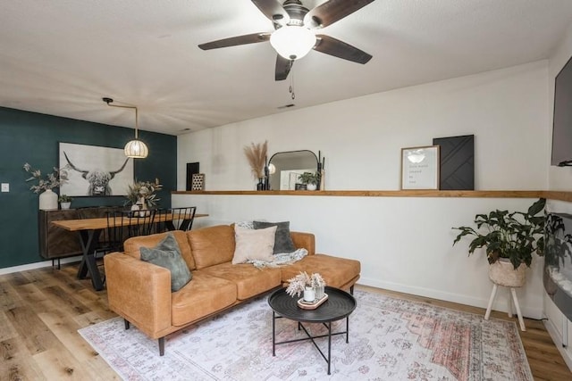 306 E Buchanan St, Baxter, IA 50028 - living area with wood finished floors, a ceiling fan, and baseboards
