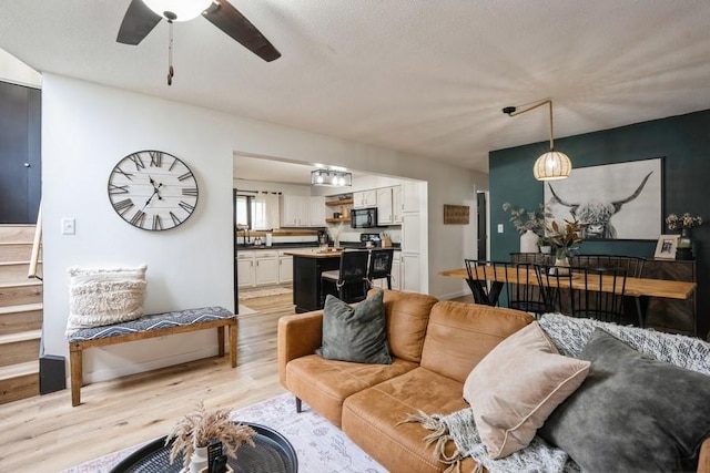 306 E Buchanan St, Baxter, IA 50028 - living room with light wood finished floors, ceiling fan, and a textured ceiling