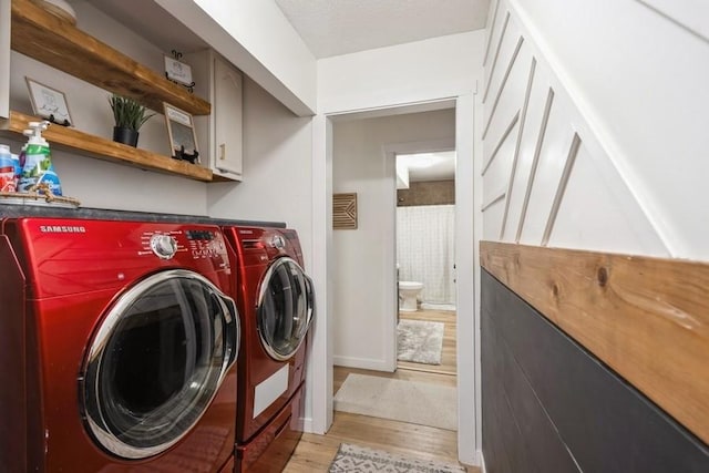 306 E Buchanan St, Baxter, IA 50028 - laundry room with independent washer and dryer, cabinet space, light wood finished floors, and baseboards