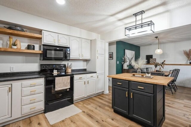 306 E Buchanan St, Baxter, IA 50028 - kitchen with black appliances, butcher block countertops, decorative light fixtures, light wood finished floors, and white cabinetry