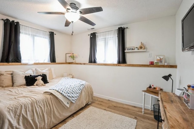 306 E Buchanan St, Baxter, IA 50028 - bedroom with wood finished floors, ceiling fan, a textured ceiling, and baseboards