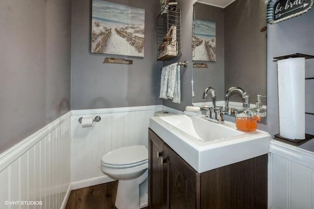 4511 66th St, Urbandale, IA 50322 - bathroom with toilet, wainscoting, wood finished floors, vanity, and a decorative wall