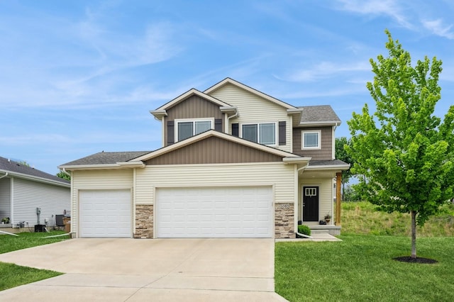 1085 Juniper Dr, Carlisle, IA 50047 - view of front of home featuring a garage, stone siding, a front yard, driveway, and board and batten siding