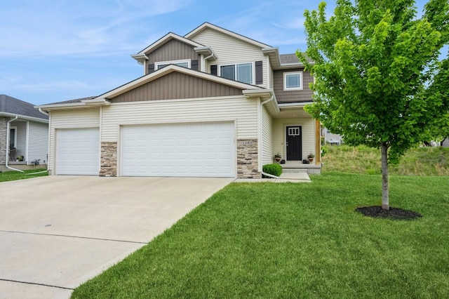 1085 Juniper Dr, Carlisle, IA 50047 - view of front facade with a garage, driveway, a front lawn, stone siding, and board and batten siding