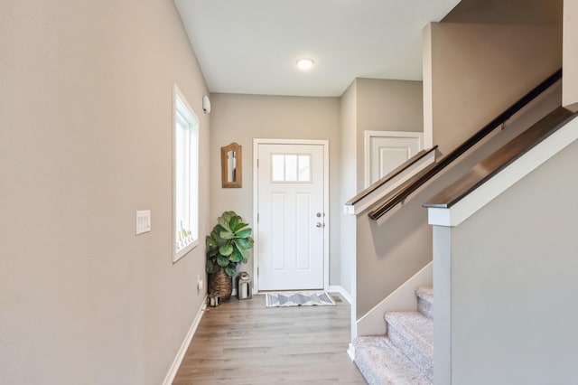 1085 Juniper Dr, Carlisle, IA 50047 - foyer entrance featuring stairway, baseboards, and light wood finished floors
