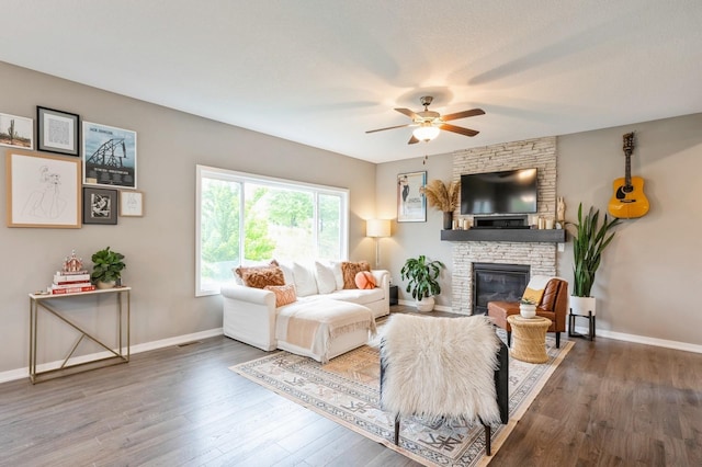 1085 Juniper Dr, Carlisle, IA 50047 - living room with a ceiling fan, wood finished floors, baseboards, and a stone fireplace