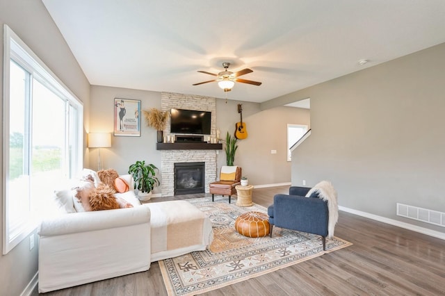 1085 Juniper Dr, Carlisle, IA 50047 - living room featuring ceiling fan, baseboards, wood finished floors, and a stone fireplace