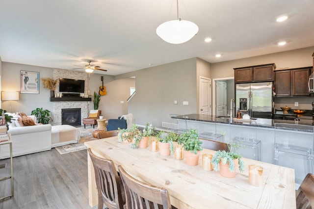 1085 Juniper Dr, Carlisle, IA 50047 - dining room featuring ceiling fan, light wood-style floors, a fireplace, and recessed lighting