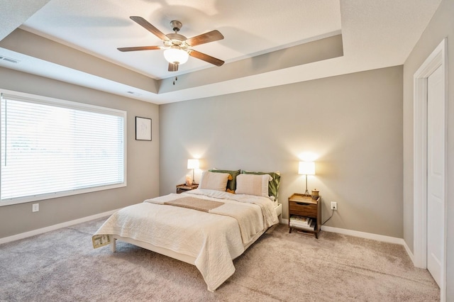 1085 Juniper Dr, Carlisle, IA 50047 - bedroom featuring a tray ceiling, light colored carpet, baseboards, and ceiling fan