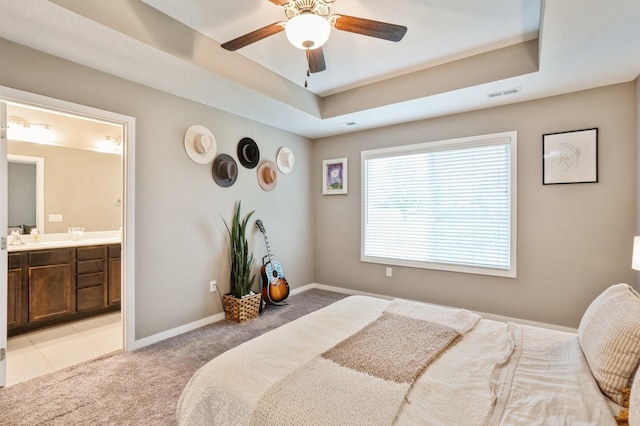1085 Juniper Dr, Carlisle, IA 50047 - bedroom featuring light carpet, a raised ceiling, baseboards, connected bathroom, and a ceiling fan