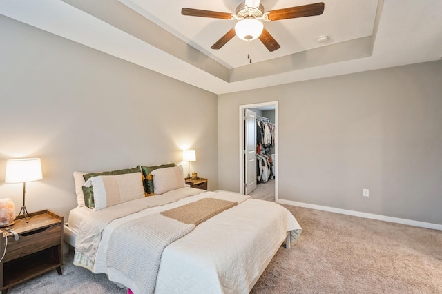 1085 Juniper Dr, Carlisle, IA 50047 - bedroom with a raised ceiling, light colored carpet, baseboards, a walk in closet, and ceiling fan