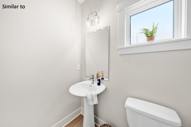 2228 Green Leaf Cir, Norwalk, IA 50211 - bathroom featuring toilet, baseboards, wood finished floors, and a sink