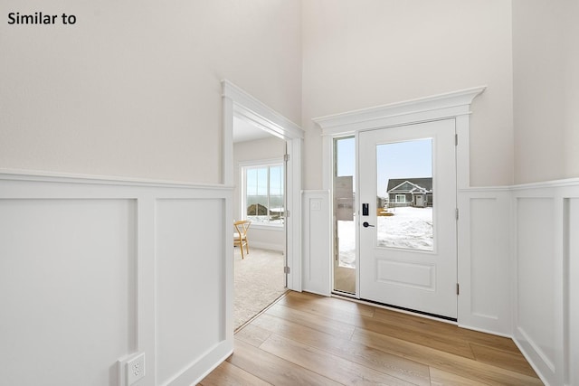 2228 Green Leaf Cir, Norwalk, IA 50211 - entrance foyer featuring wainscoting, light wood-style flooring, and a decorative wall