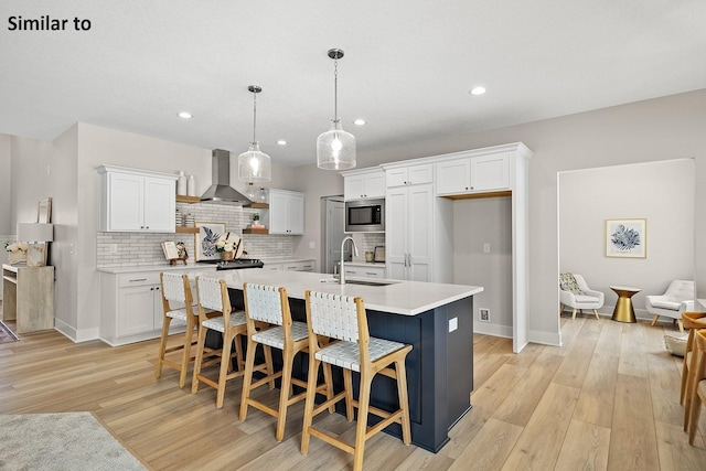 2228 Green Leaf Cir, Norwalk, IA 50211 - kitchen with stainless steel microwave, a sink, wall chimney exhaust hood, light countertops, and white cabinetry