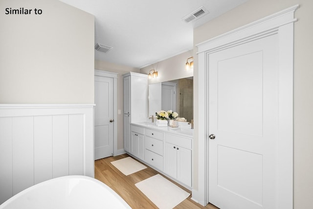 2228 Green Leaf Cir, Norwalk, IA 50211 - full bathroom with a freestanding bath, wood finished floors, double vanity, and tiled shower