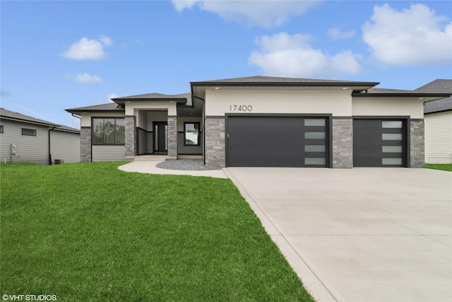 17400 Springbrook Trl, Urbandale, IA 50111 - prairie-style home with stone siding, an attached garage, concrete driveway, and a front lawn