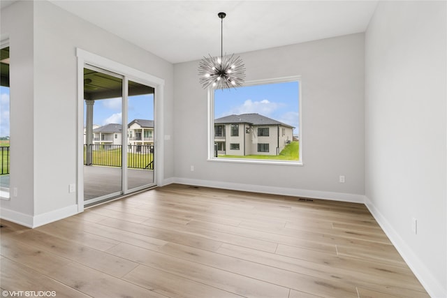 17400 Springbrook Trl, Urbandale, IA 50111 - unfurnished room featuring a chandelier, wood finished floors, and baseboards