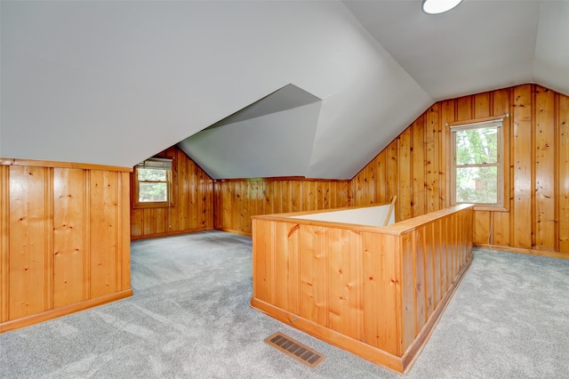 4007 68th St, Urbandale, IA 50322 - bonus room featuring vaulted ceiling, wooden walls, and light carpet