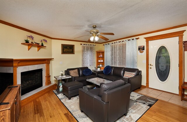 1236 63rd St, Windsor Heights, IA 50324 - living room featuring ceiling fan, wood finished floors, a textured ceiling, crown molding, and a fireplace