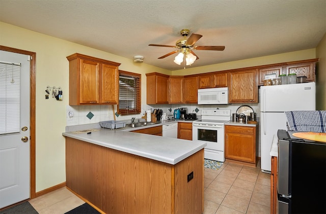 1236 63rd St, Windsor Heights, IA 50324 - kitchen featuring white appliances, a peninsula, a sink, ceiling fan, and decorative backsplash