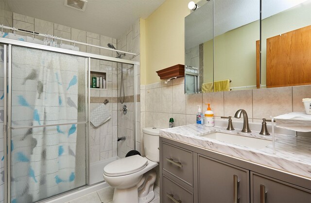 1236 63rd St, Windsor Heights, IA 50324 - full bathroom featuring a shower stall, tile patterned floors, toilet, vanity, and tile walls