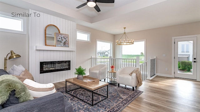 610 NW Georgetown Dr, Waukee, IA 50263 - living area with light wood-type flooring, a large fireplace, a ceiling fan, a chandelier, and baseboards