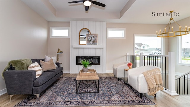610 NW Georgetown Dr, Waukee, IA 50263 - living room featuring wood finished floors, healthy amount of natural light, a chandelier, and a tray ceiling