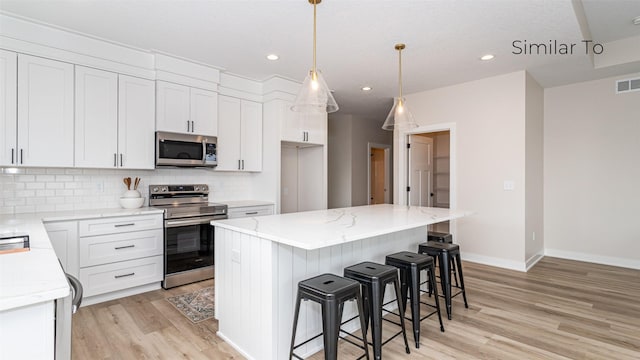 610 NW Georgetown Dr, Waukee, IA 50263 - kitchen featuring stainless steel appliances, light wood-style flooring, white cabinetry, tasteful backsplash, and baseboards
