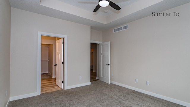610 NW Georgetown Dr, Waukee, IA 50263 - unfurnished bedroom featuring carpet floors, baseboards, and a tray ceiling
