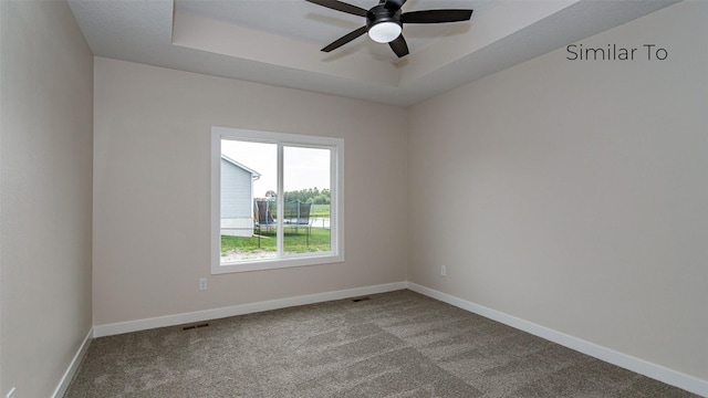 610 NW Georgetown Dr, Waukee, IA 50263 - carpeted empty room featuring ceiling fan, a raised ceiling, and baseboards