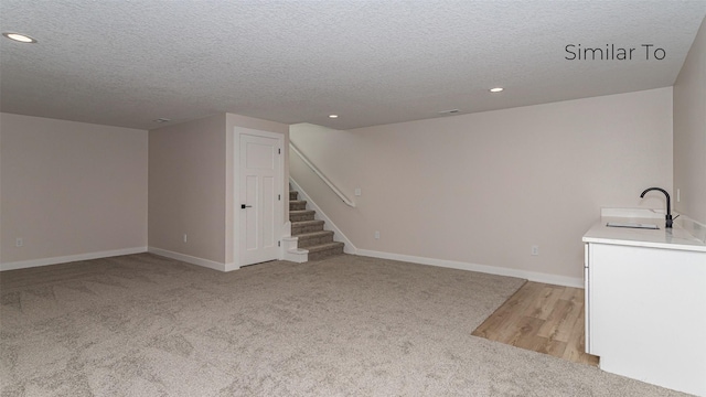 610 NW Georgetown Dr, Waukee, IA 50263 - unfurnished living room with a sink, stairway, light colored carpet, recessed lighting, and a textured ceiling