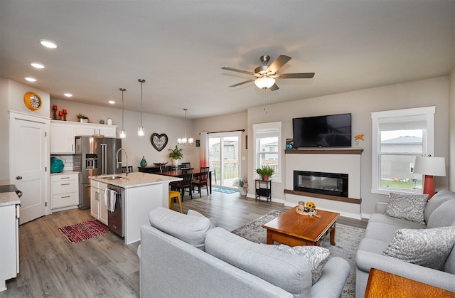 1917 Southbridge Dr, Adel, IA 50003 - living area with healthy amount of natural light, wood finished floors, a ceiling fan, recessed lighting, and a glass covered fireplace