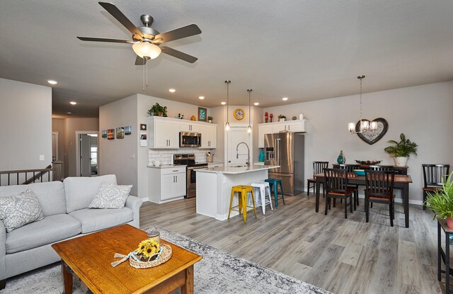 1917 Southbridge Dr, Adel, IA 50003 - living room with ceiling fan, light wood finished floors, a chandelier, and recessed lighting